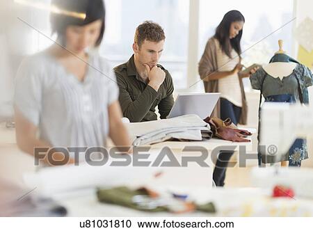 Stock Image - People working in fashion studio. Fotosearch