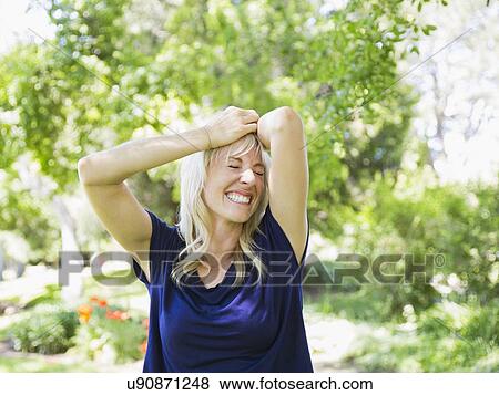 Stock Photo - Portrait of blonde woman in park. Fotosearch