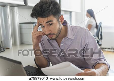 Stock Image - Portrait of businessman at work in office. Fotosearch