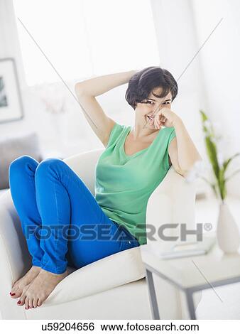 Stock Photograph - Portrait of cheerful woman relaxing at home. Fotosearch