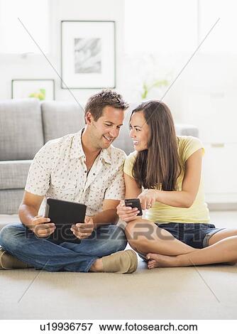 Stock Photo - Portrait of couple using digital tablet and mobile phone. Fotosearch