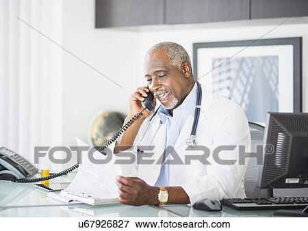 Stock Photo - Portrait of doctor talking on phone. Fotosearch