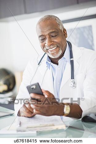 Portrait of doctor text messaging View Large Photo Image Stock Photography - Portrait of doctor text messaging. Fotosearch