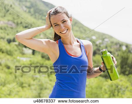 Portrait of female jogger holding bottle View Large Photo Image Stock Photo - Portrait of female jogger holding bottle. Fotosearch