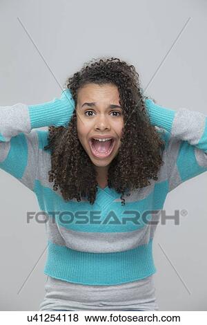 Stock Photo - Portrait of girl (12-13) screaming. Fotosearch