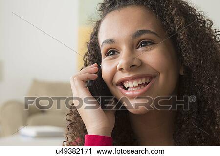 Stock Image - Portrait of girl (12-13) talking on her mobile. Fotosearch