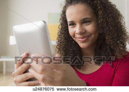 Stock Photography - Portrait of girl (12-13) with digital tablet. Fotosearch