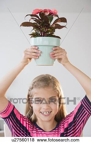Portrait of girl (8-9) holding flower pot View Large Photo Image Stock Photo - Portrait of girl (8-9) holding flower pot. Fotosearch