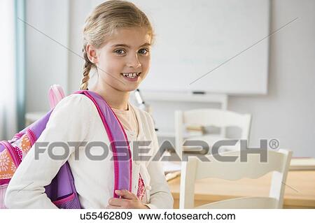 Stock Photo - Portrait of girl (8-9) in classroom. Fotosearch