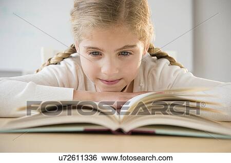 Portrait of girl (8-9) reading book View Large Photo Image Stock Photograph - Portrait of girl (8-9) reading book. Fotosearch