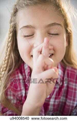 Stock Image - Portrait of girl (8-9) wishing with fingers crossed. Fotosearch