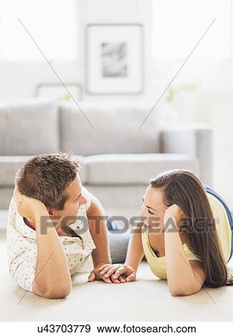 Stock Photo - Portrait of happy couple lying on side, face to face. Fotosearch