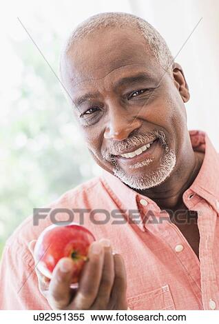 Portrait of man holding red apple View Large Photo Image Stock Photography - Portrait of man holding red apple. Fotosearch