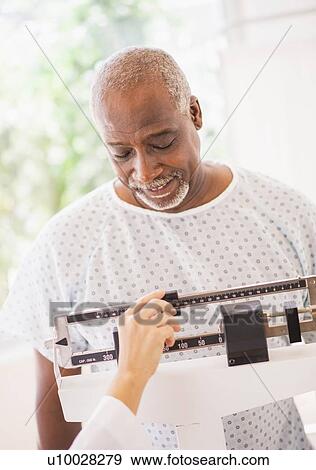 Portrait of man standing on weight scale View Large Photo Image Stock Photo - Portrait of man standing on weight scale. Fotosearch