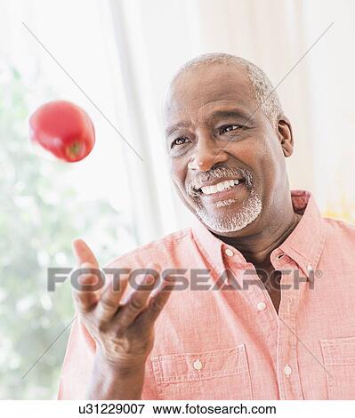 Portrait of man throwing red apple View Large Photo Image Stock Photo - Portrait of man throwing red apple. Fotosearch