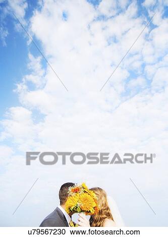 Portrait of married couple kissing behind bouquet View Large Photo Image Stock Image - Portrait of married couple kissing behind bouquet. Fotosearch