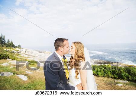 Stock Photograph - Portrait of married couple kissing. Fotosearch