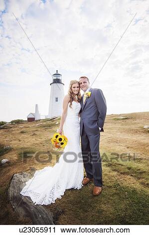 Stock Image - Portrait of married couple, lighthouse in background. Fotosearch