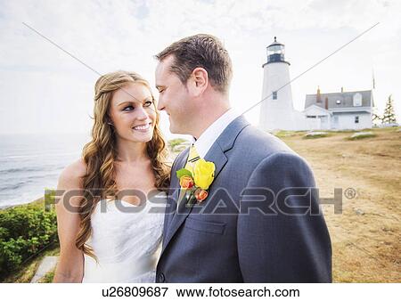Stock Photo - Portrait of married couple, lighthouse in background. Fotosearch