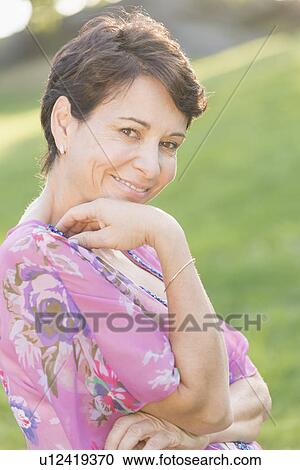 Portrait of mature woman smiling outdoors View Large Photo Image Stock Image - Portrait of mature woman smiling outdoors. Fotosearch