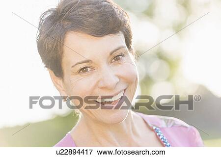 Portrait of mature woman smiling outdoors View Large Photo Image Stock Photo - Portrait of mature woman smiling outdoors. Fotosearch