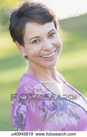 Portrait of mature woman smiling outdoors View Large Photo Image Stock Photo - Portrait of mature woman smiling outdoors. Fotosearch