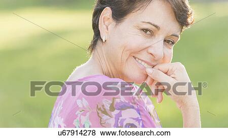 Portrait of mature woman smiling outdoors View Large Photo Image Stock Photo - Portrait of mature woman smiling outdoors. Fotosearch