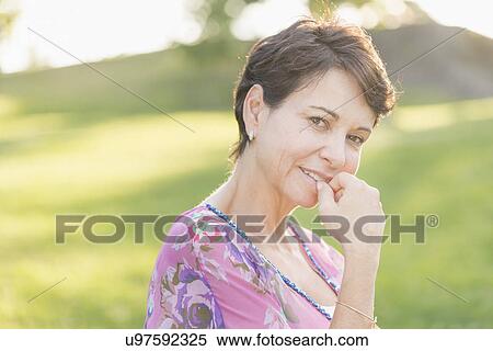 Stock Photography - Portrait of mature woman smiling outdoors. Fotosearch