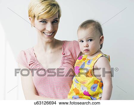 Picture - Portrait of mother holding daughter (12-17 months). Fotosearch