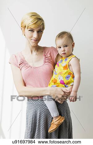 Picture - Portrait of mother holding daughter (12-17 months). Fotosearch