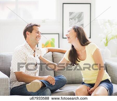 Stock Photo - Portrait of playful couple on sofa. Fotosearch