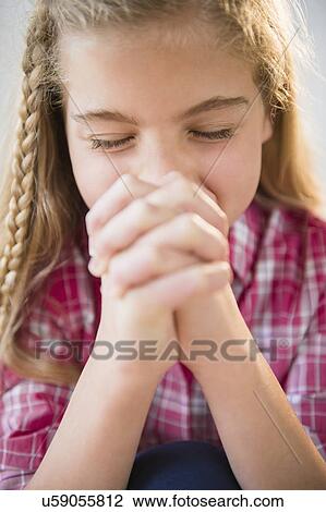 Stock Image - Portrait of praying girl (8-9). Fotosearch