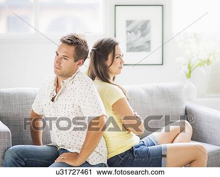 Portrait of sad couple on sofa, back to back View Large Photo Image Stock Image - Portrait of sad couple on sofa, back to back. Fotosearch