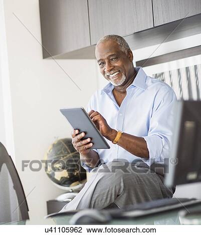 Portrait of senior man using digital tablet in office View Large Photo Image Stock Image - Portrait of senior man using digital tablet in office. Fotosearch