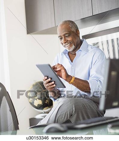 Portrait of senior man using digital tablet in office View Large Photo Image Stock Photograph - Portrait of senior man using digital tablet in office. Fotosearch
