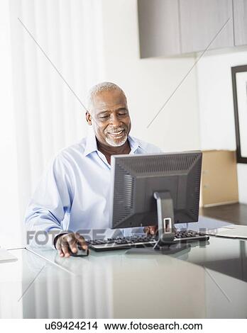 Portrait of senior man working on computer in office View Large Photo Image Picture - Portrait of senior man working on computer in office. Fotosearch