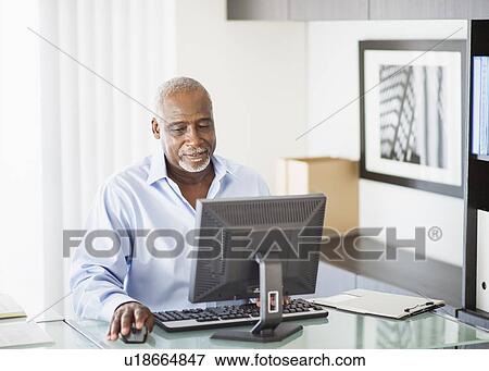 Portrait of senior man working on computer in office View Large Photo Image Stock Photo - Portrait of senior man working on computer in office. Fotosearch