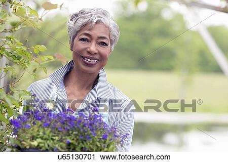 Portrait of senior woman working in garden View Large Photo Image Stock Image - Portrait of senior woman working in garden. Fotosearch