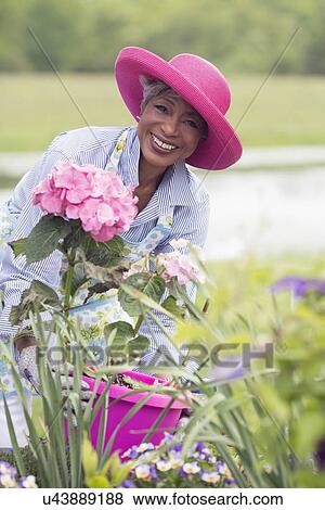 Stock Photo - Portrait of senior woman working in garden. Fotosearch