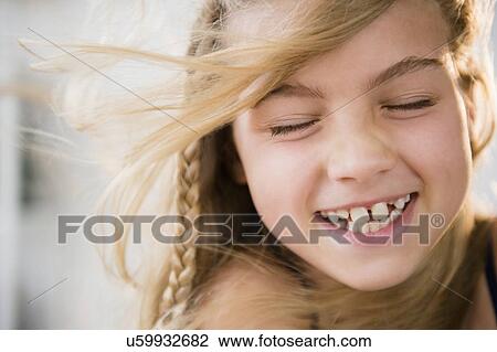 Stock Image - Portrait of smiling blonde girl (8-9). Fotosearch