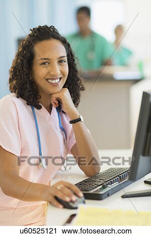 Portrait of smiling female doctor working at desks in hospital View Large Photo Image Stock Image - Portrait of smiling female doctor working at desks in hospital. Fotosearch