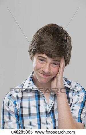Stock Photography - Portrait of teenage boy (14-15) making a face. Fotosearch