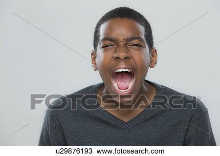 Stock Image - Portrait of teenage boy (14-15) shouting. Fotosearch