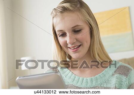 Stock Image - Portrait of teenage girl (14-15) with digital tablet. Fotosearch