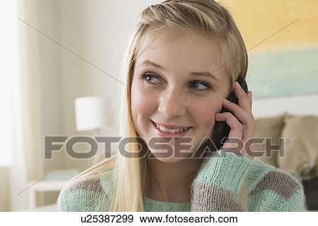 Stock Photo - Portrait of teenage girl (14-15) with smartphone. Fotosearch