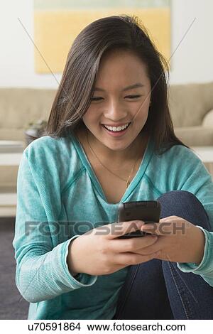 Picture - Portrait of teenage girl (16-17) with smartphone. Fotosearch