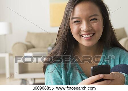 Stock Photography - Portrait of teenage girl (16-17) with smartphone. Fotosearch