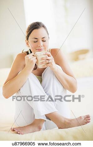 Portrait of woman enjoying tea in bed View Large Photo Image Stock Photography - Portrait of woman enjoying tea in bed. Fotosearch