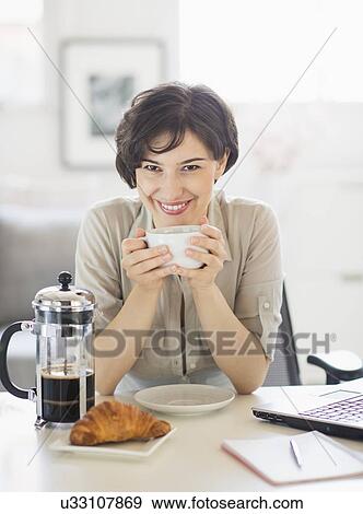 Stock Photo - Portrait of woman holding coffee cup. Fotosearch