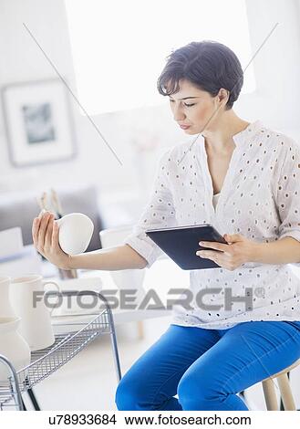 Picture - Portrait of woman in art studio using digital tablet. Fotosearch